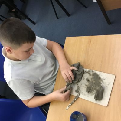 Children making clay lizards
